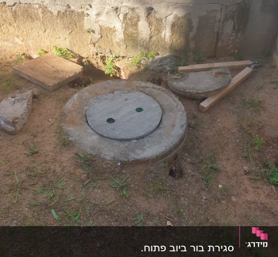 מכסה ביוב עגול עם כלי עבודה לידו